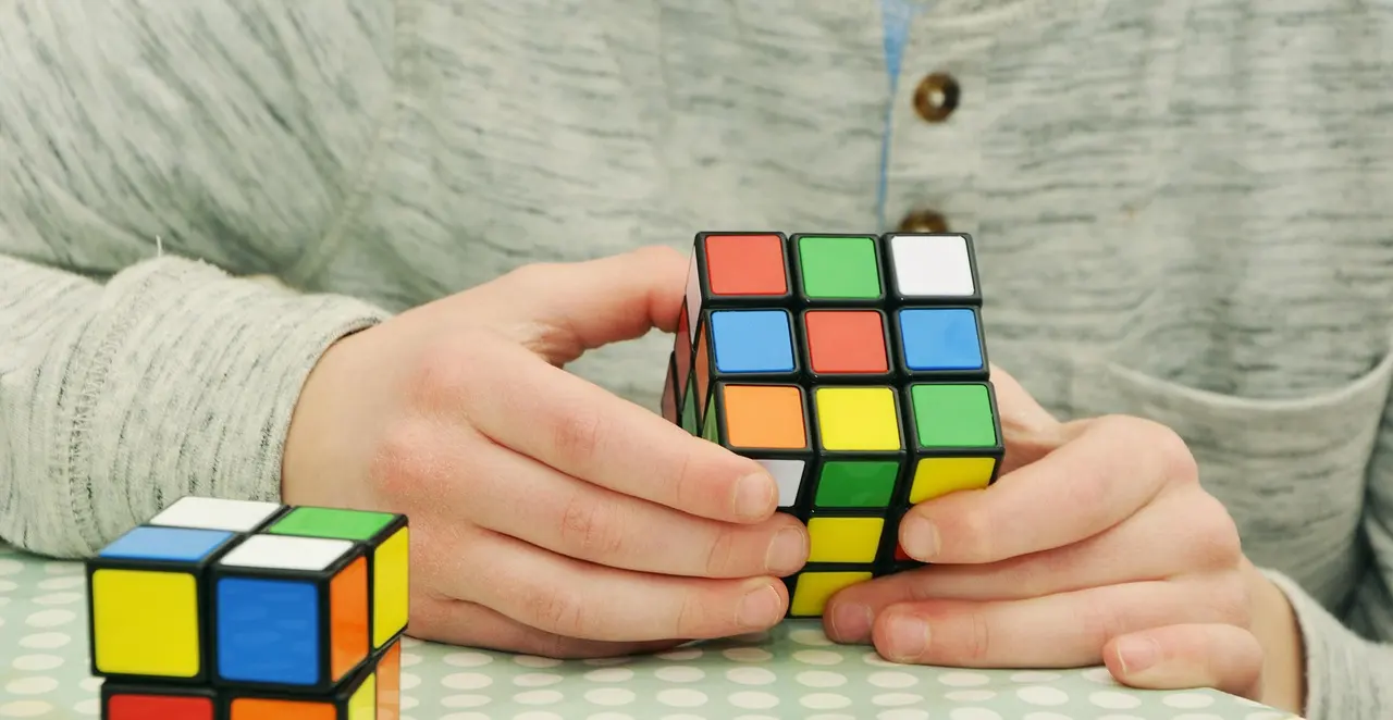 Person solving a jigsaw puzzle on a wooden table