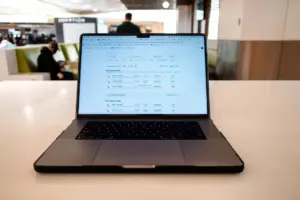 Traveller checking a flight booking on a laptop at an airport cafe